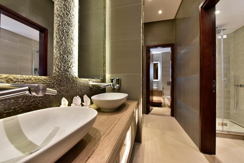 a bathroom with a sink and a mirror at Bahrain Airport Hotel Airside Hotel for Transiting and Departing Passengers only in Muharraq