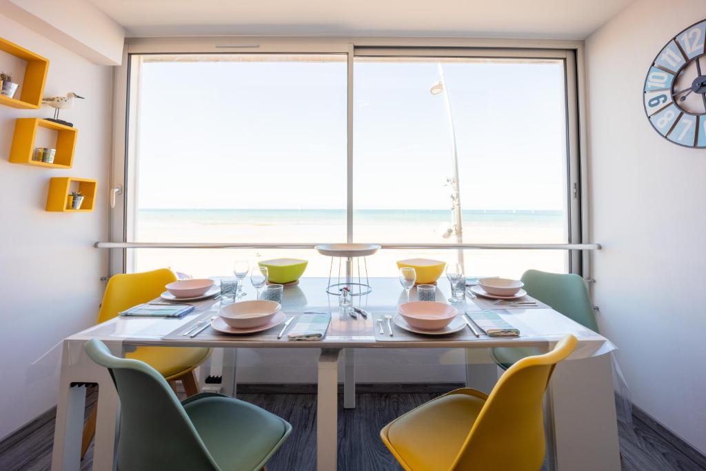 濱海庫爾瑟萊的住宿－Les Vagues，一间带桌椅和大窗户的用餐室