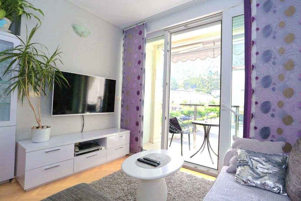 een woonkamer met een bank en een tv bij Luxury Family Apartment Omiš in Omiš