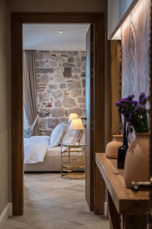 a bedroom with a bed and a stone wall at Apartments Hun in Kotor
