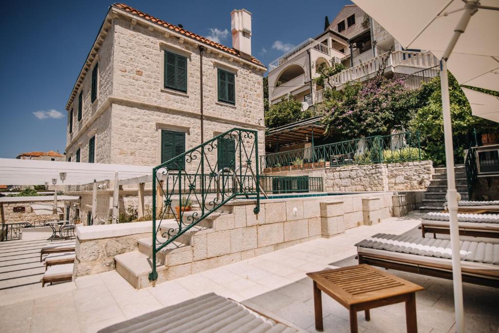 patio ze stołem, parasolem i budynkiem w obiekcie Villa Allure of Dubrovnik w Dubrowniku