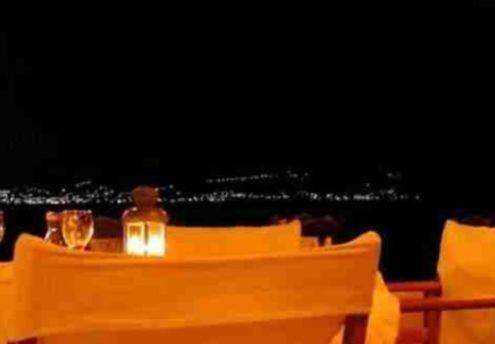 a table with a view of the ocean with chairs at Agistri Club Hotel in Skliri