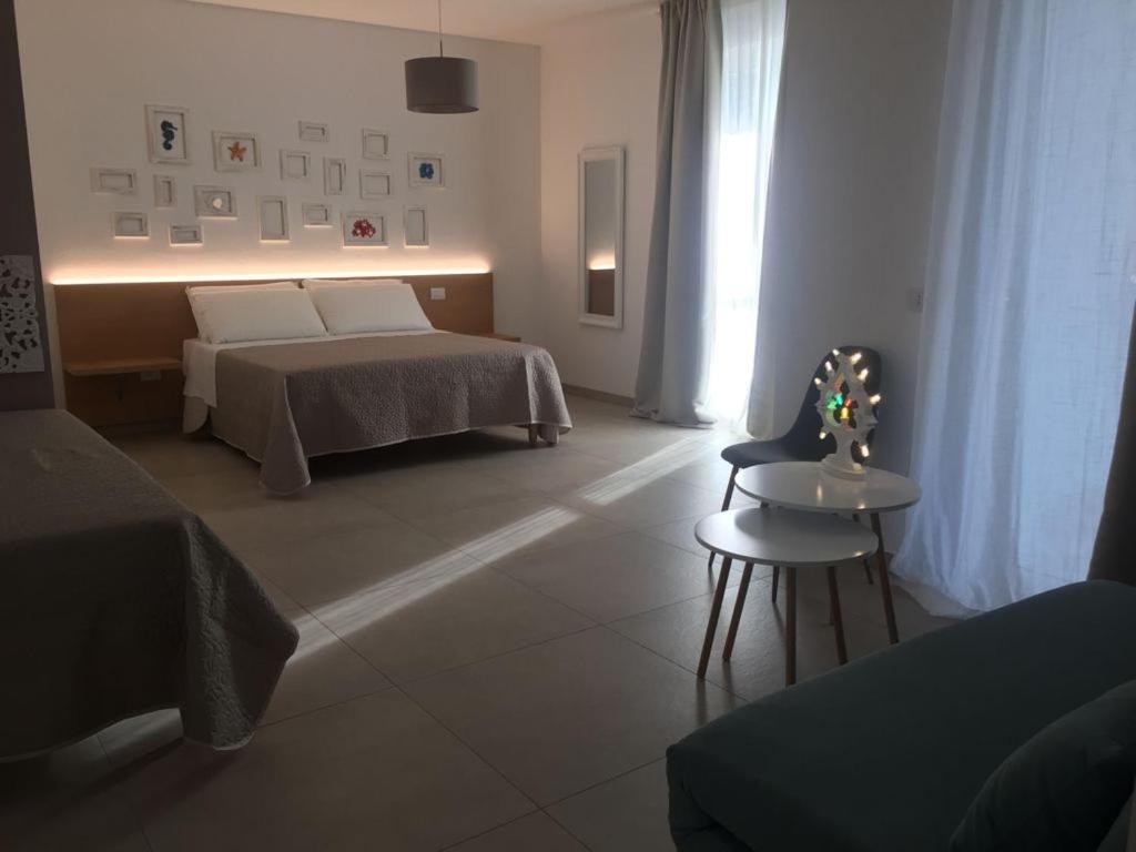 a bedroom with a bed and a table and a chair at LE RONDINI HOUSE in Monopoli