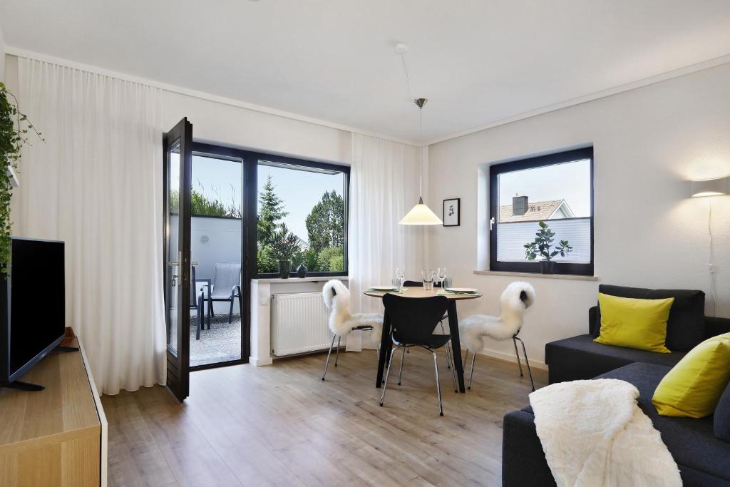 a living room with a couch and a table and chairs at Ferienwohnung Silvia in Weißensberg