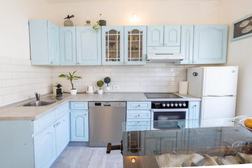 - une cuisine avec des placards bleus et un évier dans l'établissement Apartman Glavina, à Makarska