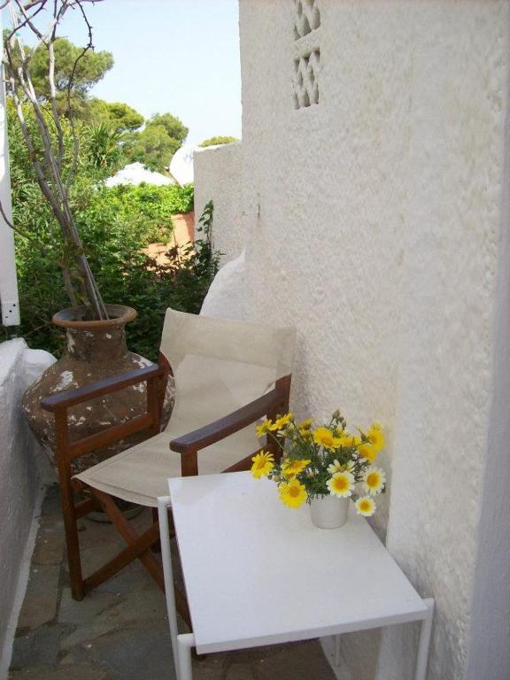 a chair and a table with flowers on it at Agistri Club Hotel in Skliri