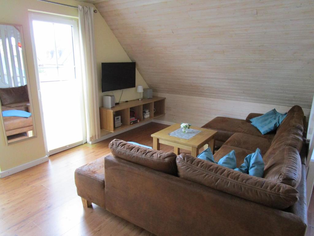 伯爾格倫德－雷特維施的住宿－Ferienwohnung Möwe mit eigener Sauna，客厅配有棕色沙发和桌子