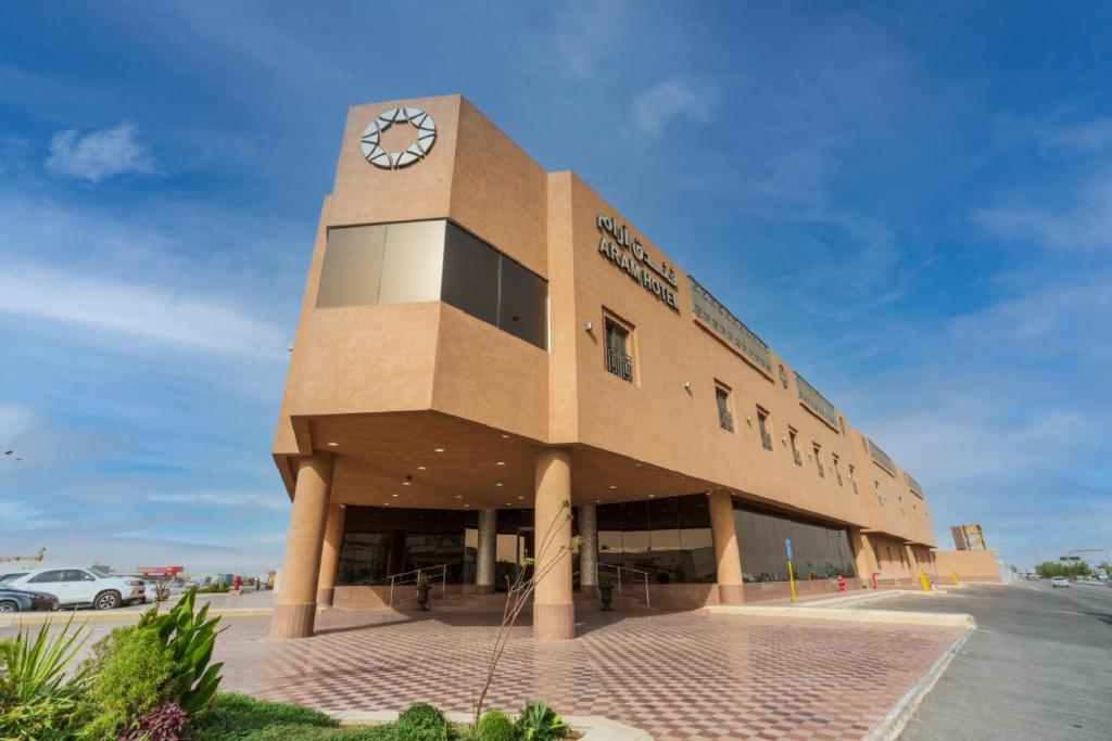 a building with a clock on the side of it at Aram Hotel - AlMeshael Exit 18 in Riyadh