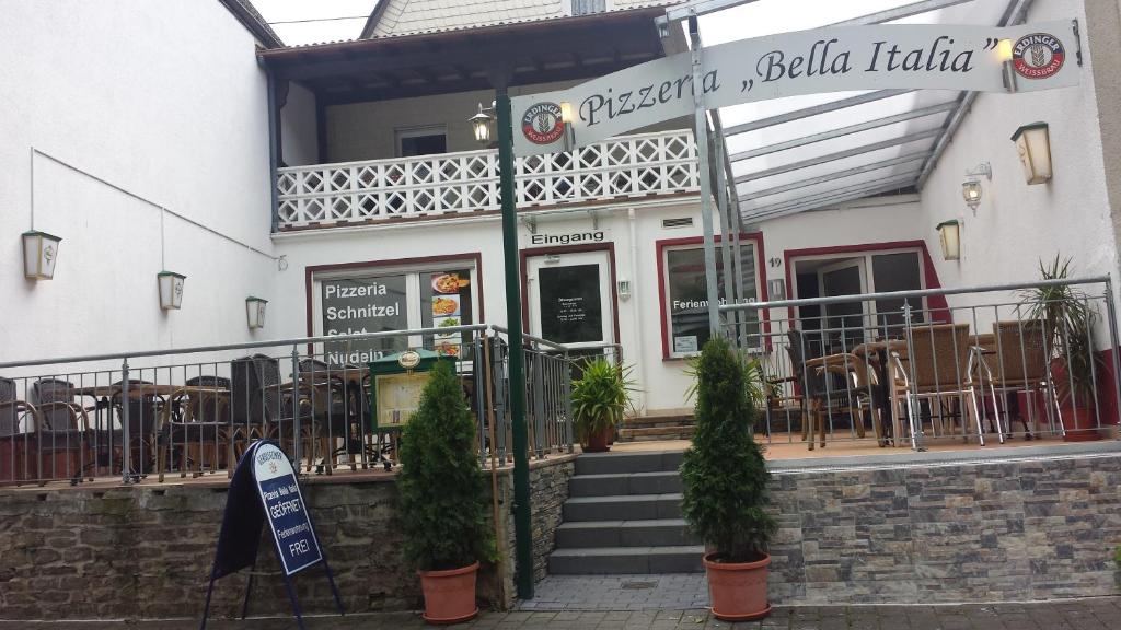 a restaurant with tables and chairs in front of a building at Bella Italia in Bruttig-Fankel