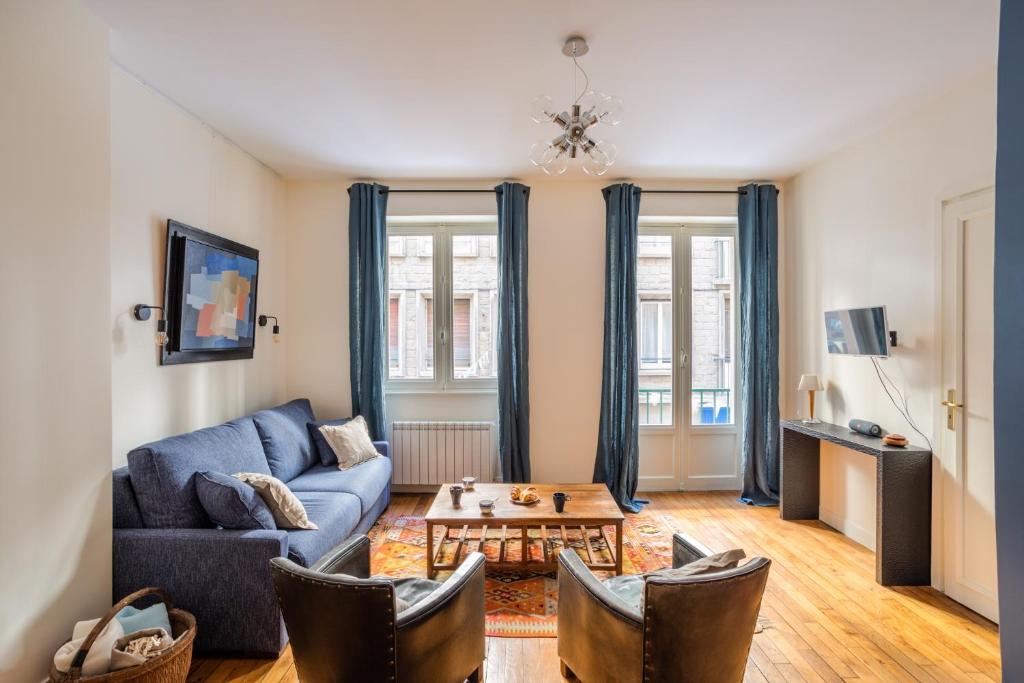 een woonkamer met een blauwe bank en een tafel bij Le Traou Mad - Au cœur de l'Intra-muros in Saint-Malo