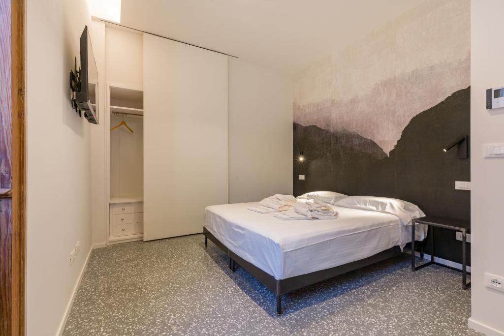 una camera da letto con un letto e un quadro sul muro di Domus la Scala a Verona