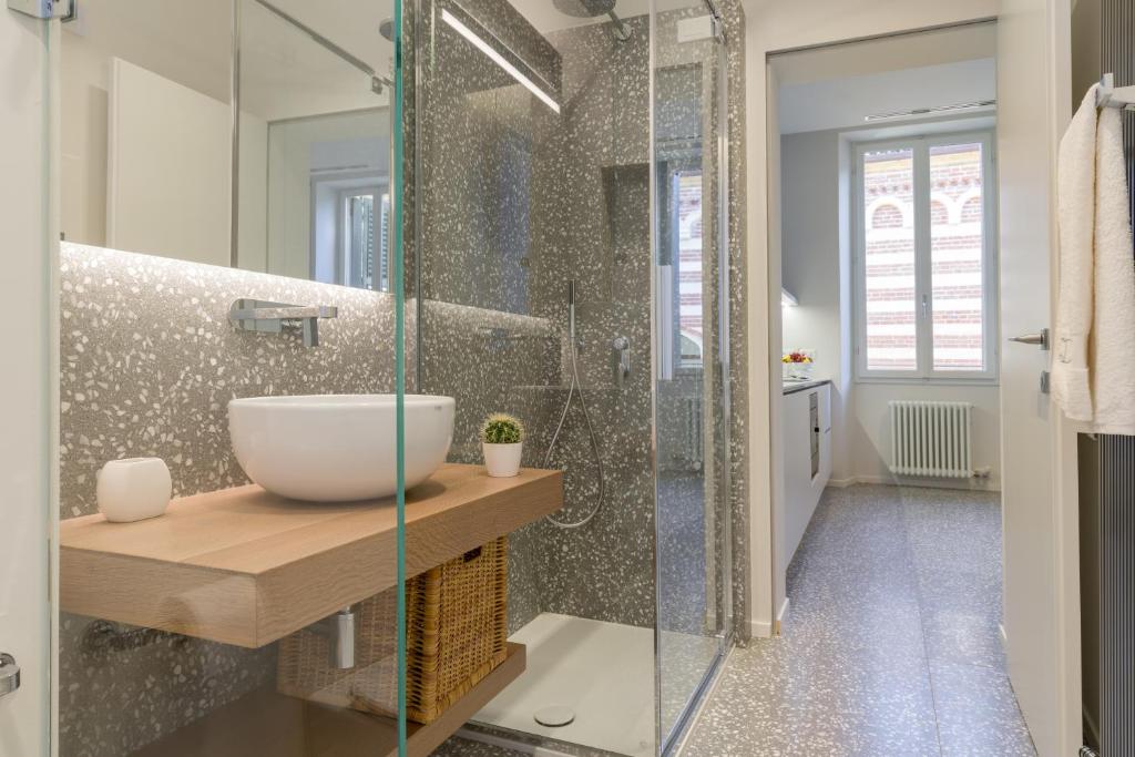 bagno con lavandino e doccia in vetro di Domus la Scala a Verona