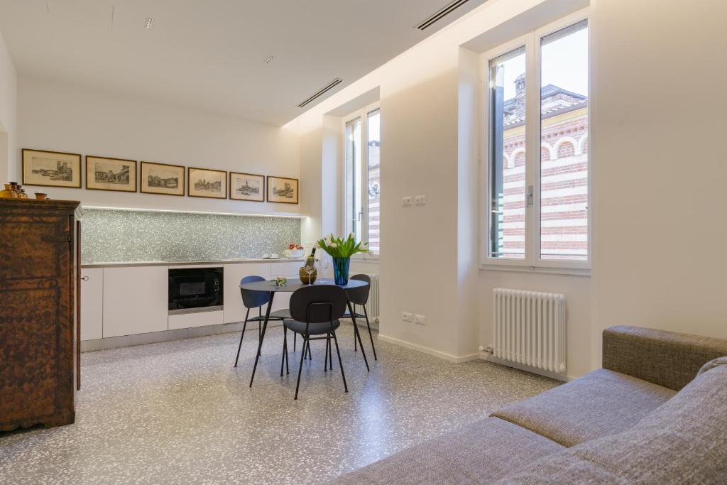 un soggiorno con divano e tavolo con sedie di Domus la Scala a Verona