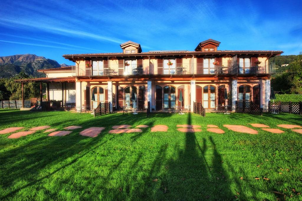 una casa grande con un gran patio delante en Agriturismo alla Poncia, en Gravedona