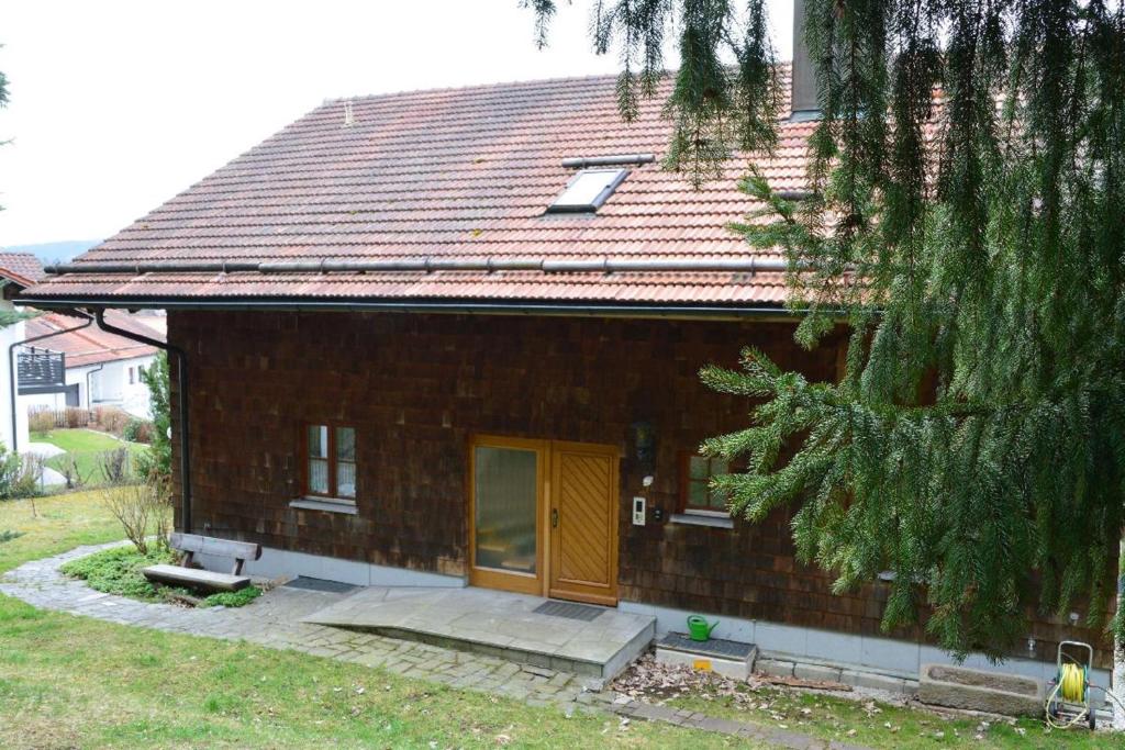 a small brick house with a yellow door at Ferienhaus Killian in Bischofsmais