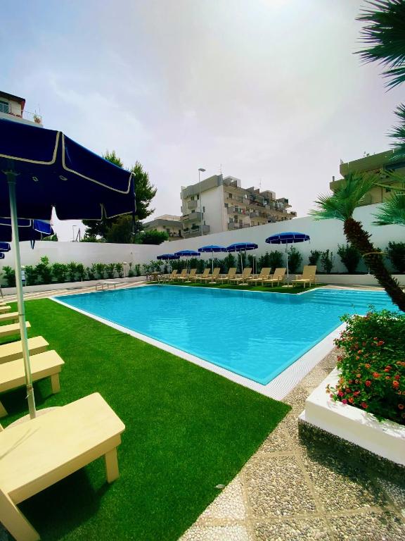 a large swimming pool with chairs and umbrellas at Vittoria Parc Hotel in Bari