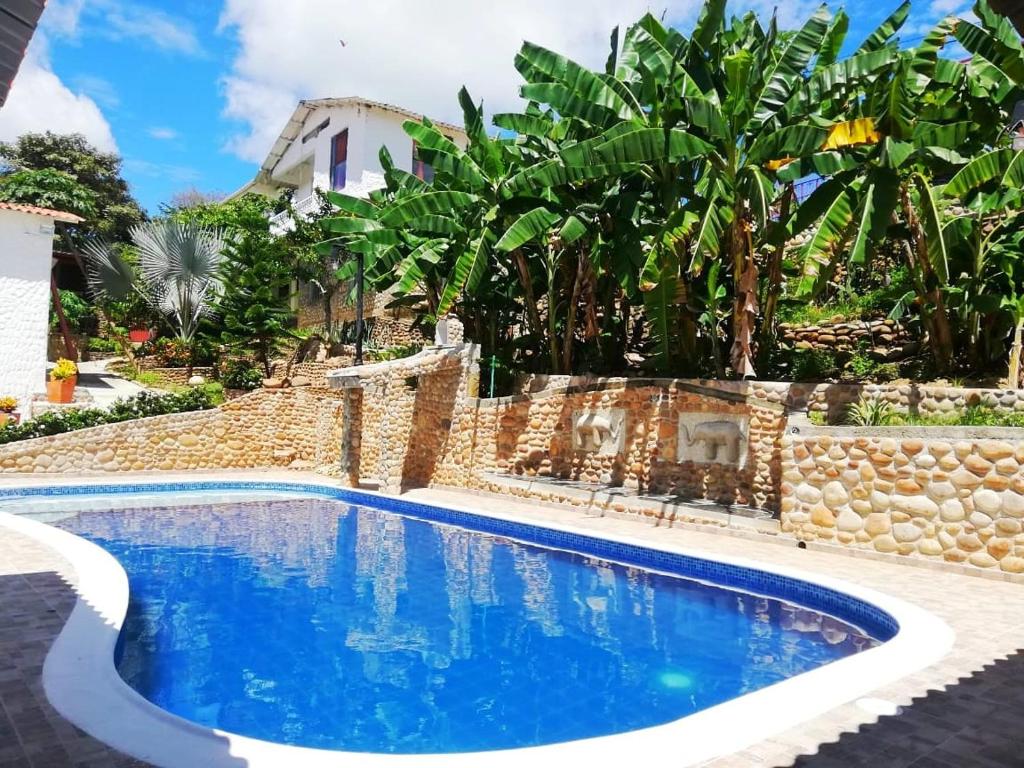 a pool in front of a house with trees at FINCA VILLA MAGALY en medio de la Naturaleza in Melgar