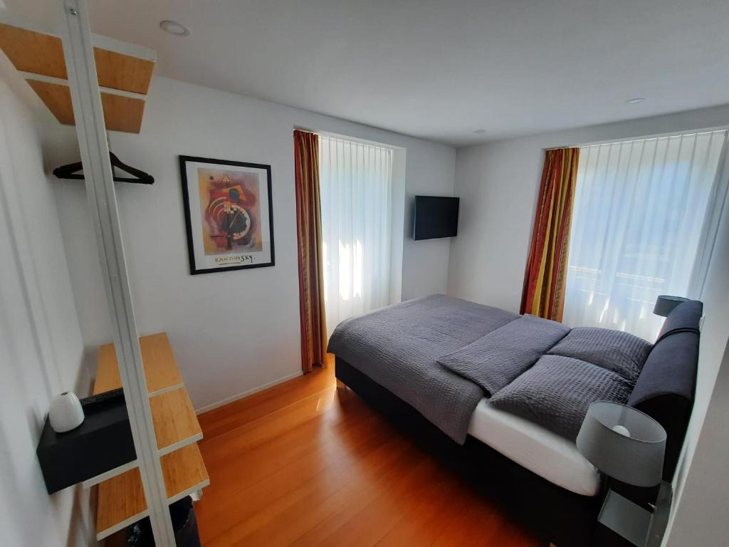 um quarto com uma cama, uma escada e janelas em B&B Cà Nosa em Gordevio