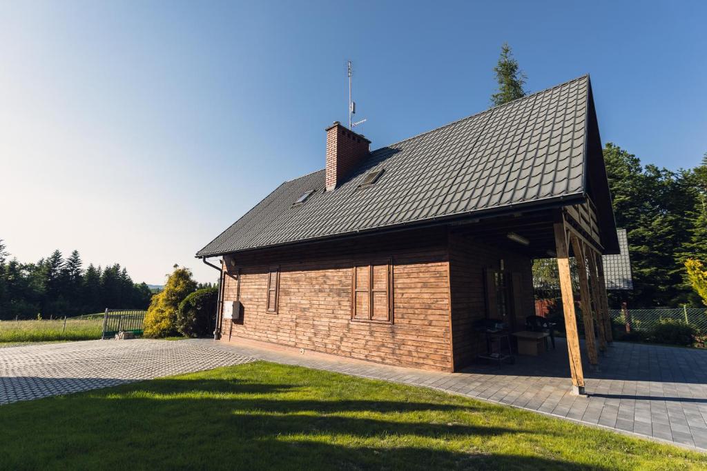 a small brick building with a gambrel roof at Klimkowskie Zacisze - domek całoroczny in Klimkówka