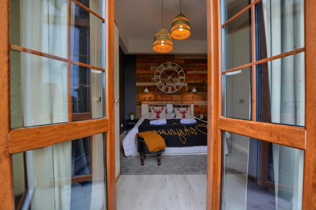 Cette chambre comprend un lit et une horloge murale. dans l'établissement Apartament Fajny Kąt, à Ustrzyki Dolne