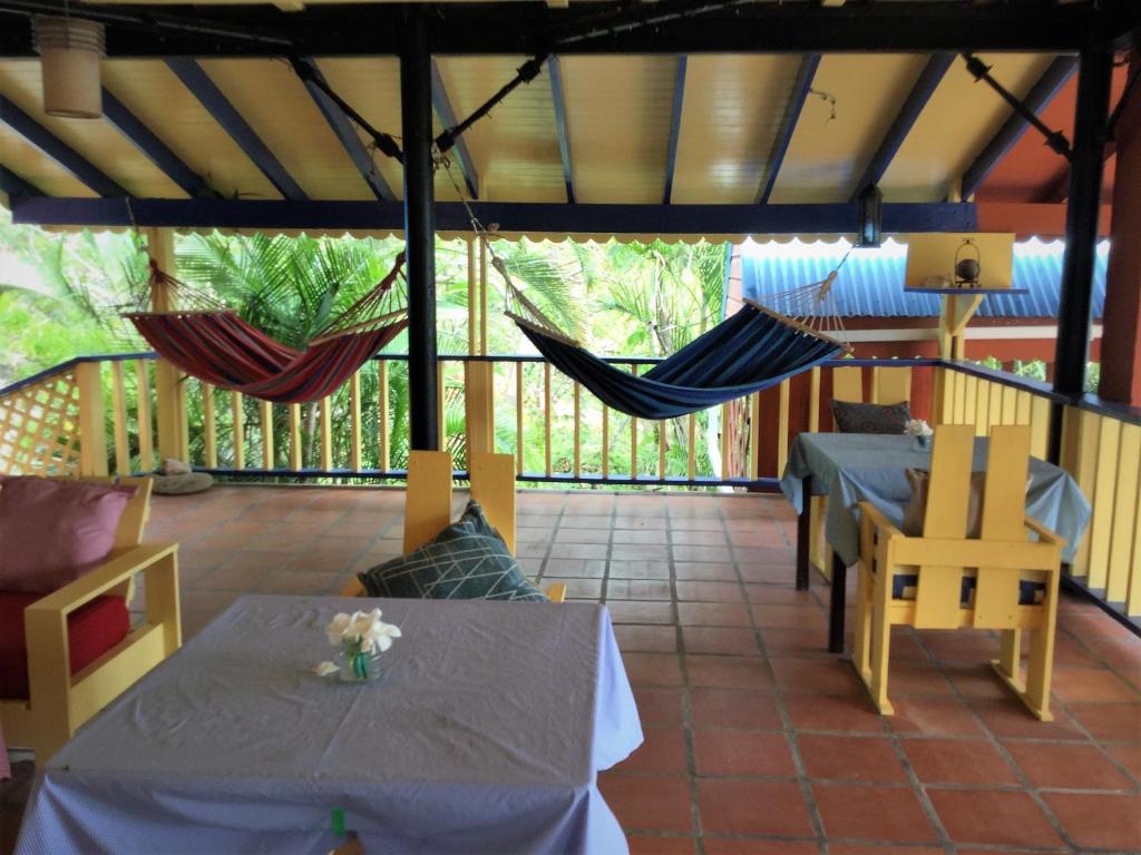 a screened porch with two tables and hammocks at The Sweet Retreat in Port Elizabeth