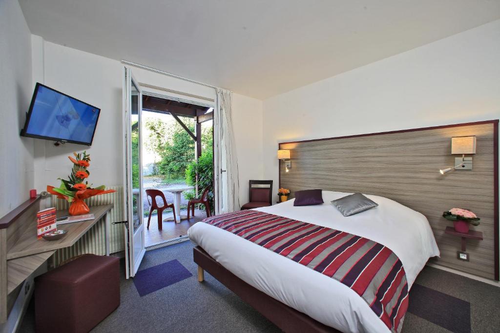 サントにあるHôtel O'Nice Saintesのベッドとテレビが備わるホテルルームです。