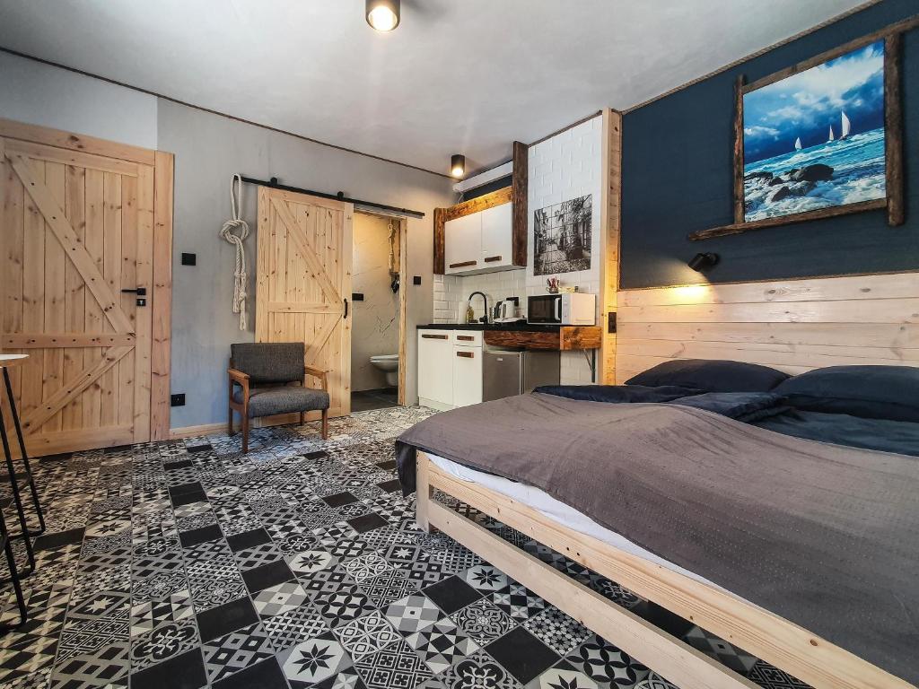 ein Schlafzimmer mit einem Bett und einem Tisch sowie eine Küche in der Unterkunft Mazurska 8a in Olsztyn