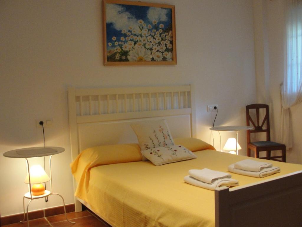 a bedroom with a yellow bed with two towels on it at El Balcón de Alange in Alange
