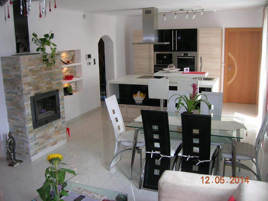 a kitchen and dining room with a table and a fireplace at Appartement Fortuna in Saalfelden am Steinernen Meer