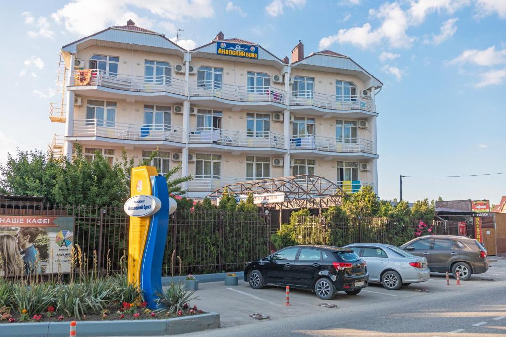 a large building with cars parked in front of it at Hotel Anapskiy Briz in Anapa