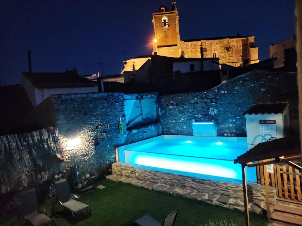 uma piscina ao lado de um edifício à noite em Casa Rural el Rincón de Monfragüe em Malpartida de Plasencia