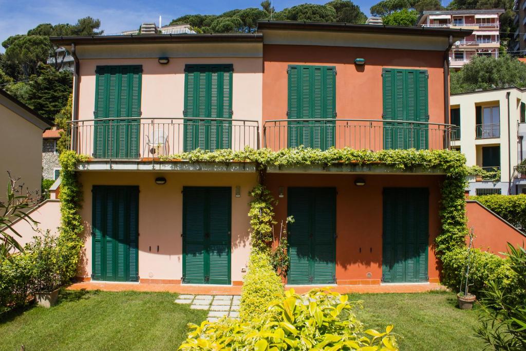 an apartment building with green shutters on it at Baia Blu RTA Residence in Lerici