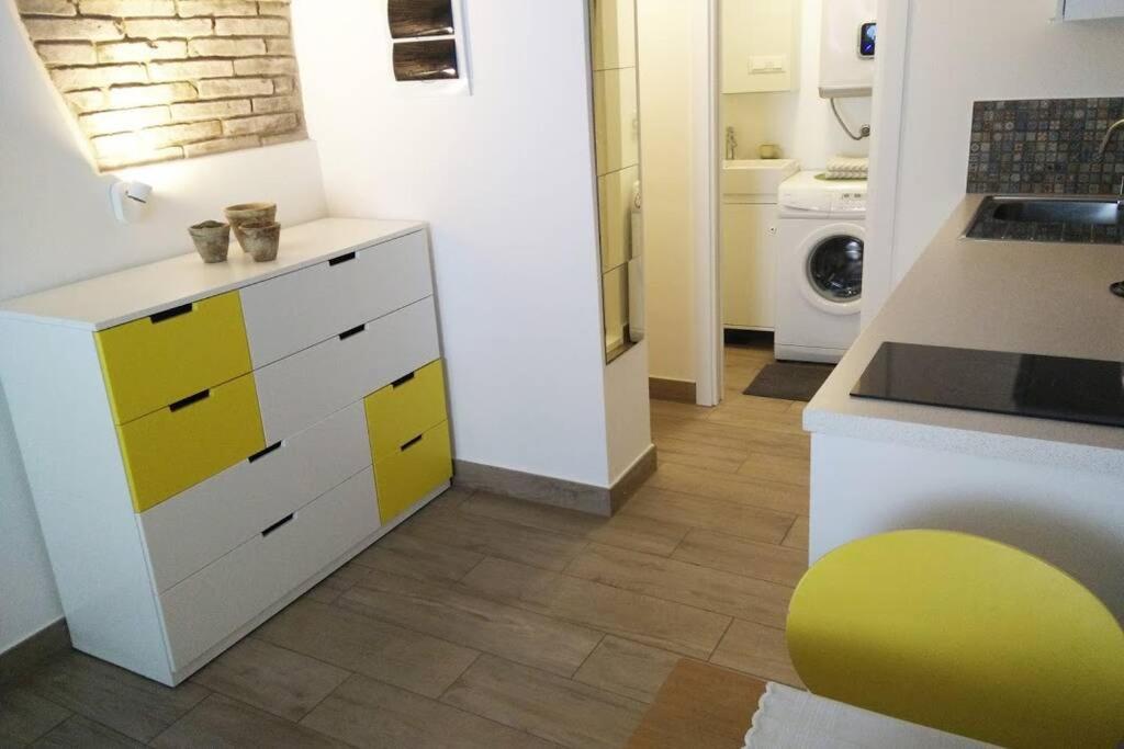 - une cuisine avec des placards jaunes et blancs dans une pièce dans l'établissement OLD TOWN 14, à Ljubljana