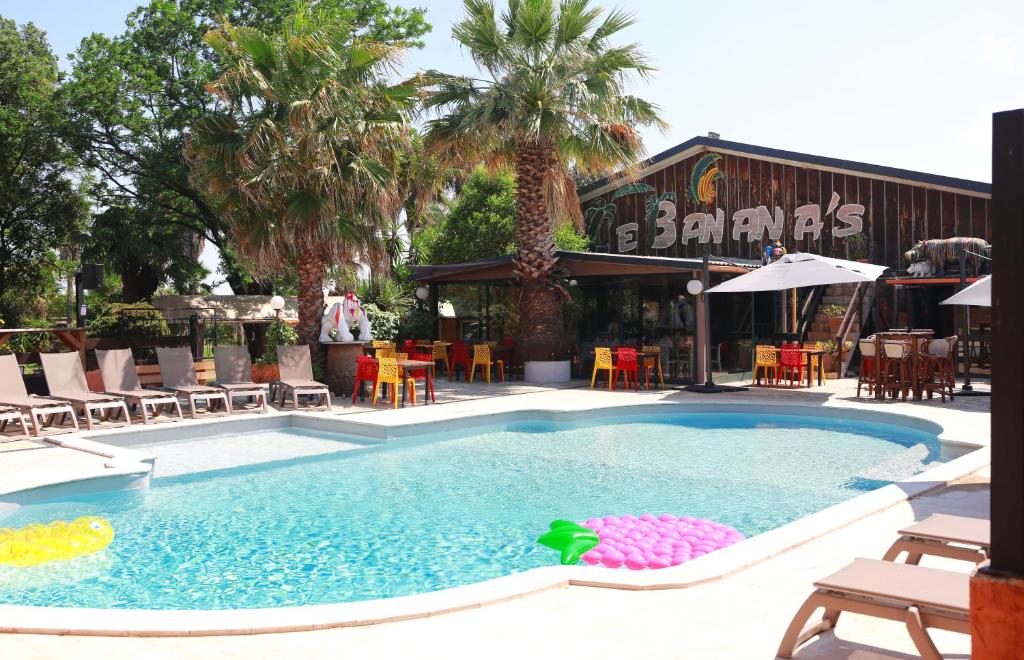 a swimming pool in front of a restaurant at Le Banana's in Aléria