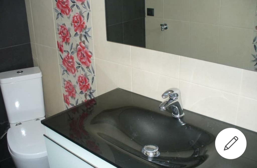 a bathroom with a black sink and a toilet at La betia in Litochoro
