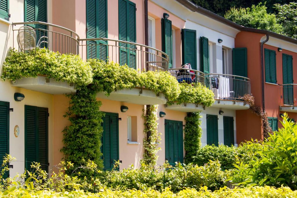 a building with green shutters and plants on it at Baia Blu RTA Residence in Lerici