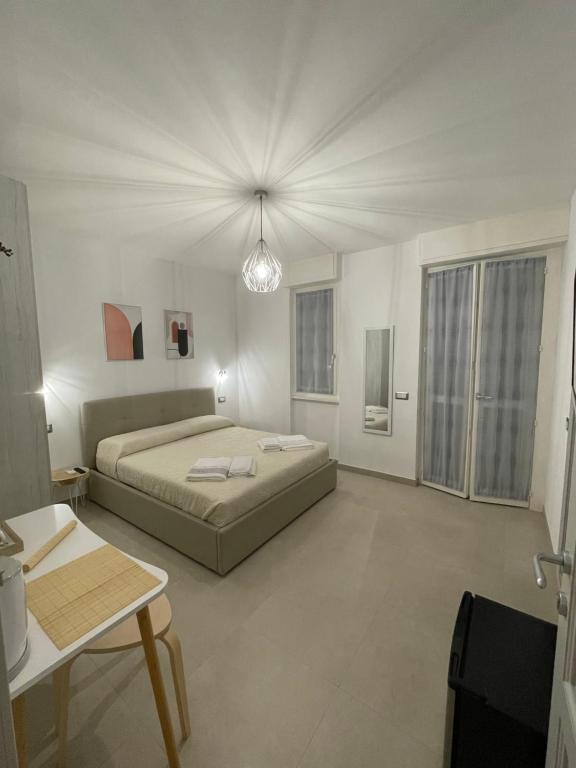 a white bedroom with a bed and a table at Alguer 74 in Alghero
