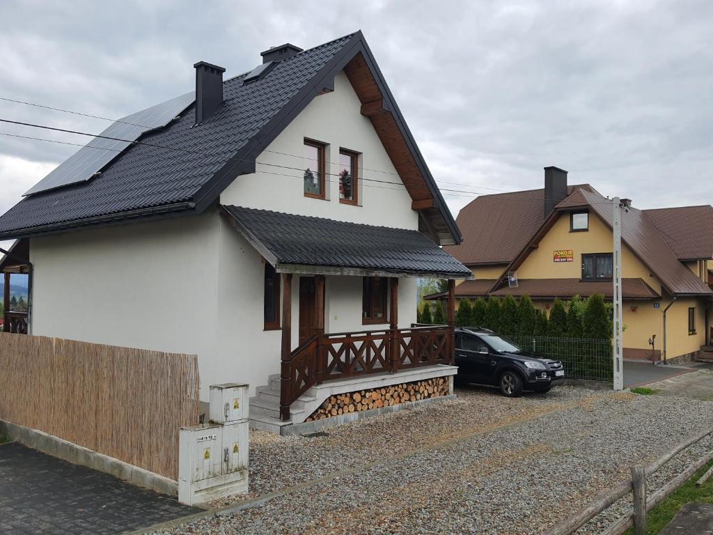 a white house with a black roof at Domek na Polnej in Czorsztyn