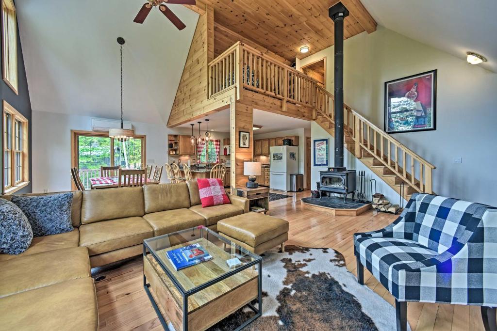 a living room with a couch and a staircase at Rustic North Creek Getaway about 4 Mi to Gore Mtn! in North Creek