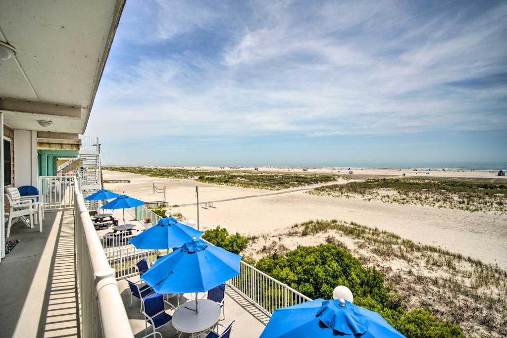 a balcony with blue umbrellas and the beach at Charming Oceanfront Condo, Walk to Wildwood Beach in Wildwood Crest