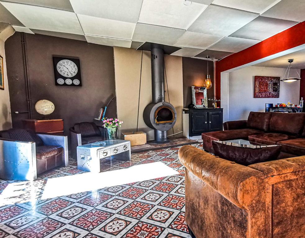 uma sala de estar com um sofá e uma lareira em La passerelle em Pouzols