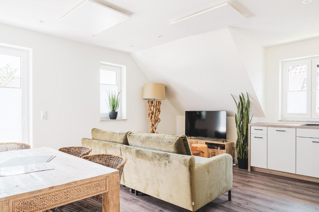 a living room with a couch and a tv at Dünenquartier Apartment 30 in Zingst