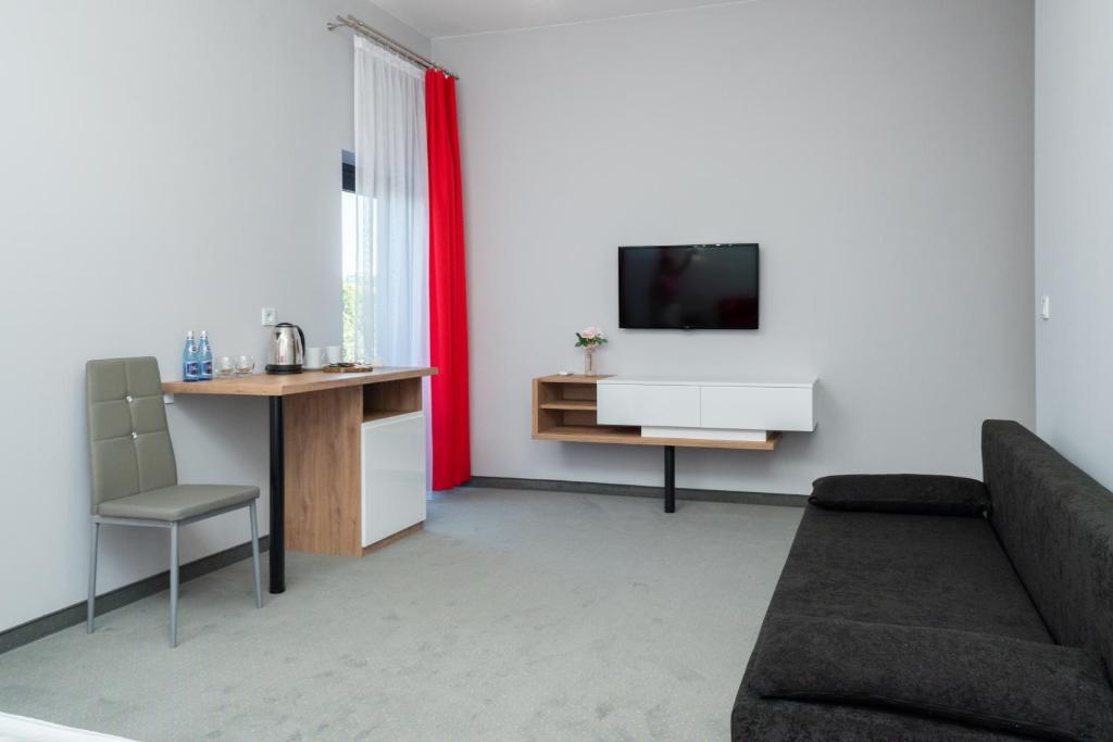 Televízia a/alebo spoločenská miestnosť v ubytovaní Aquila Hotel