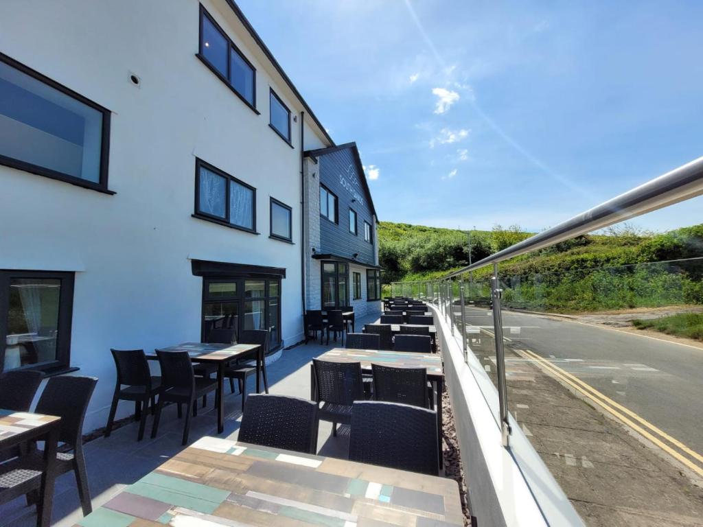 a patio with tables and chairs on the side of a building at South Sands Hotel in Weston-super-Mare