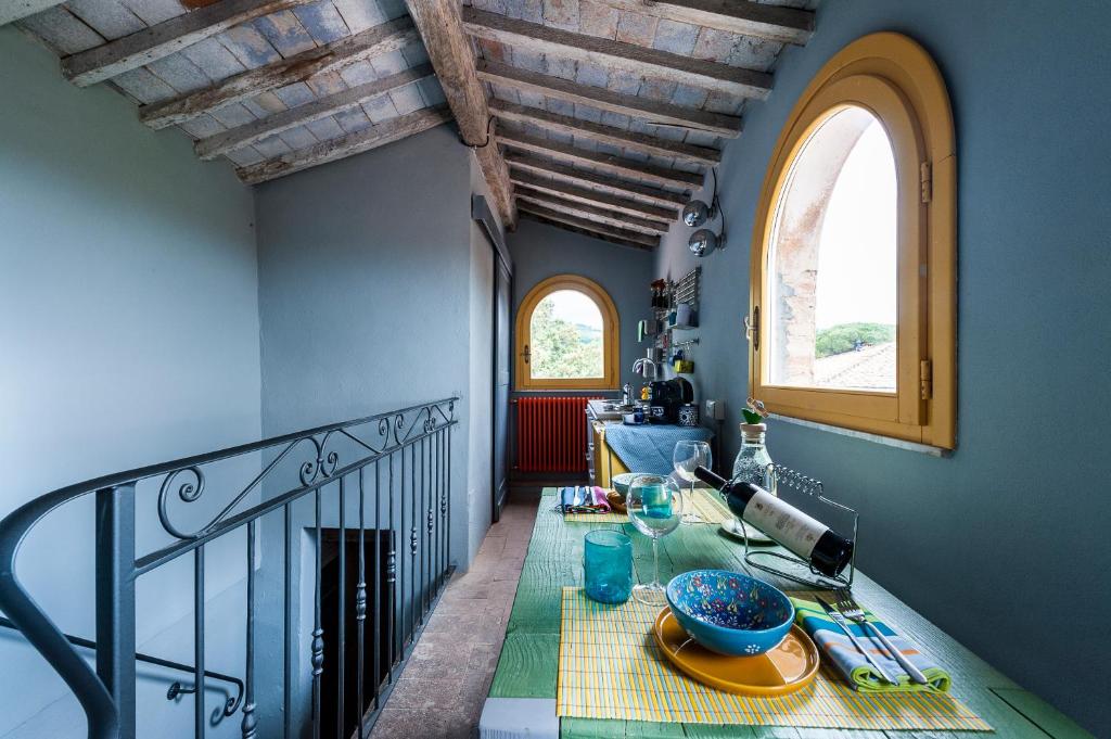 una sala da pranzo con tavolo e balcone di La Casa Rossa degli Artisti a Casciana Terme