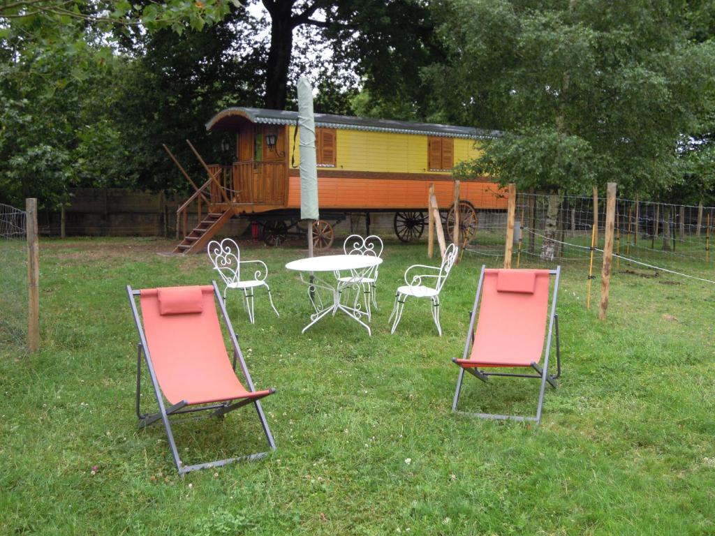 un gruppo di sedie e un tavolo di fronte a una casa di CHARLOTTE LA ROULOTTE a Grosbreuil