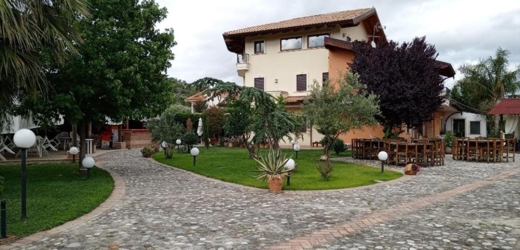 a house with a walkway in front of a yard at B&b kabbala club in Lattarico
