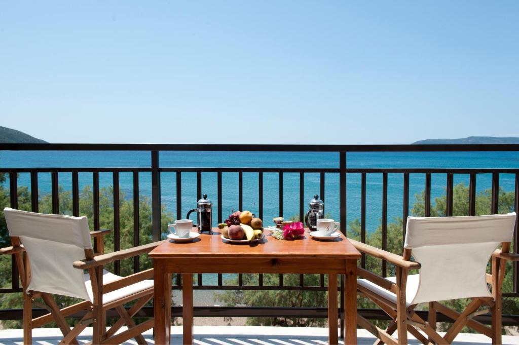 a table with a bowl of fruit on a balcony at Hotel Korakakis Beach in Finikounta