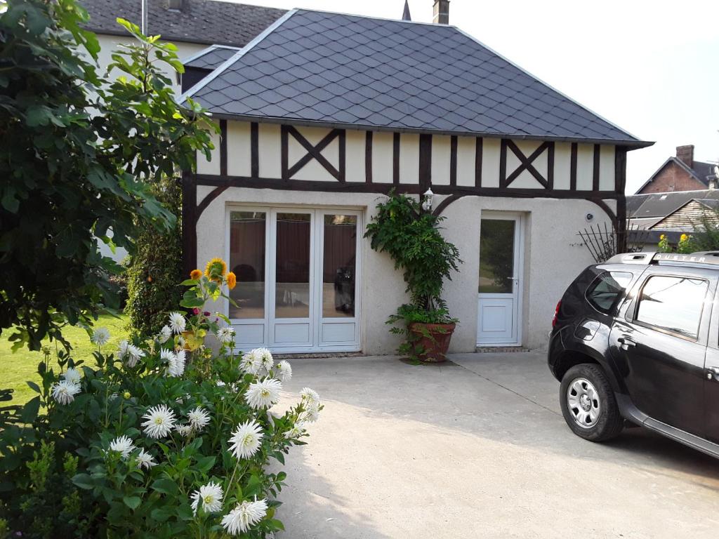 une maison noire et blanche avec une voiture garée dans l'allée. dans l'établissement Maison( Clesanie ), 