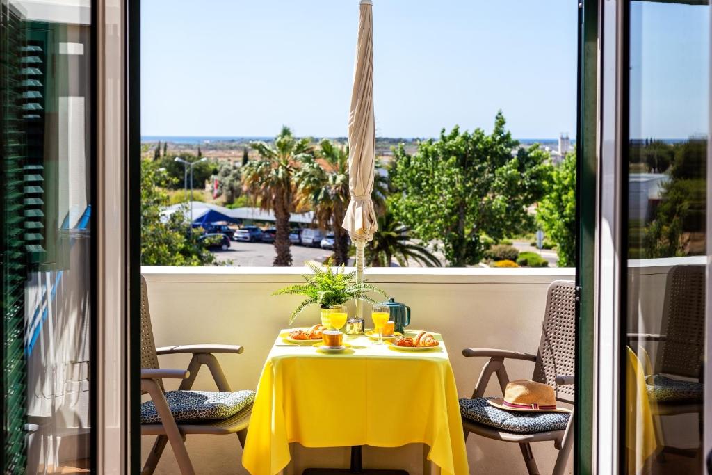 une table avec un chiffon de table jaune sur un balcon dans l'établissement sunny apartment with sea view, à Tavira